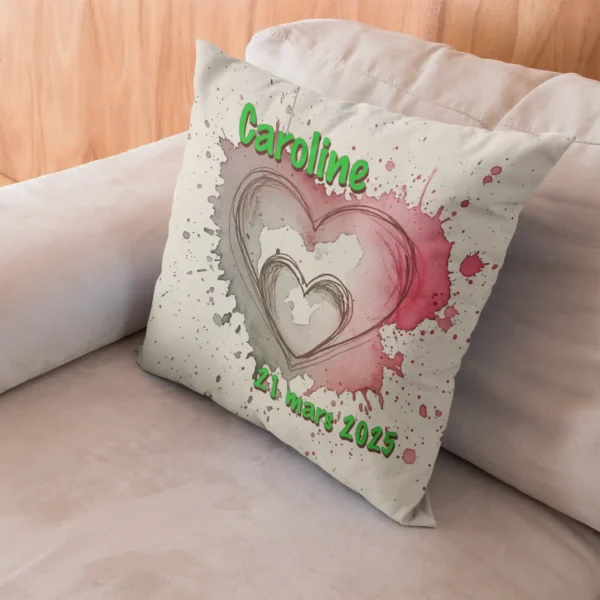 Coussin faire part naissance posé dans l'angle d'un canapé