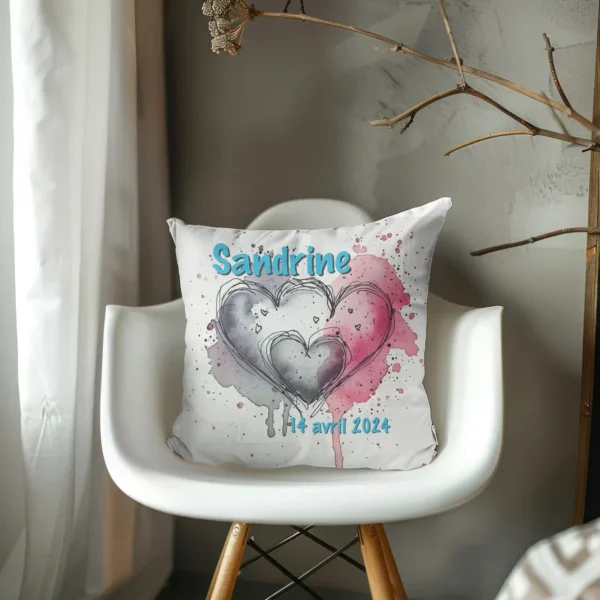 Coussin Naissance papa maman posé dans un fauteuil blanc moderne